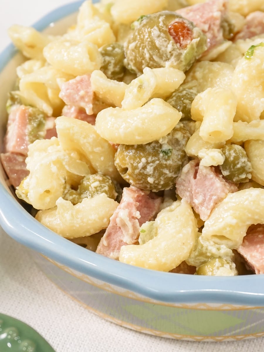 a spam, macaroni, olive, and pea salad in a small bowl