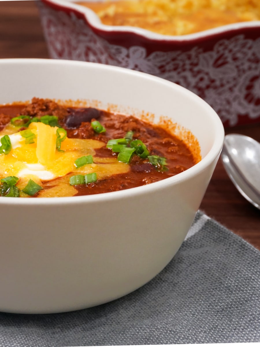 a bowl of chili topped with cheese and scallion