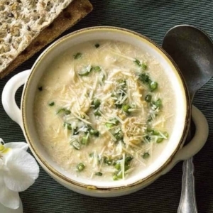 brazilian sopa de palmito in a bowl topped with cheese and cilantro