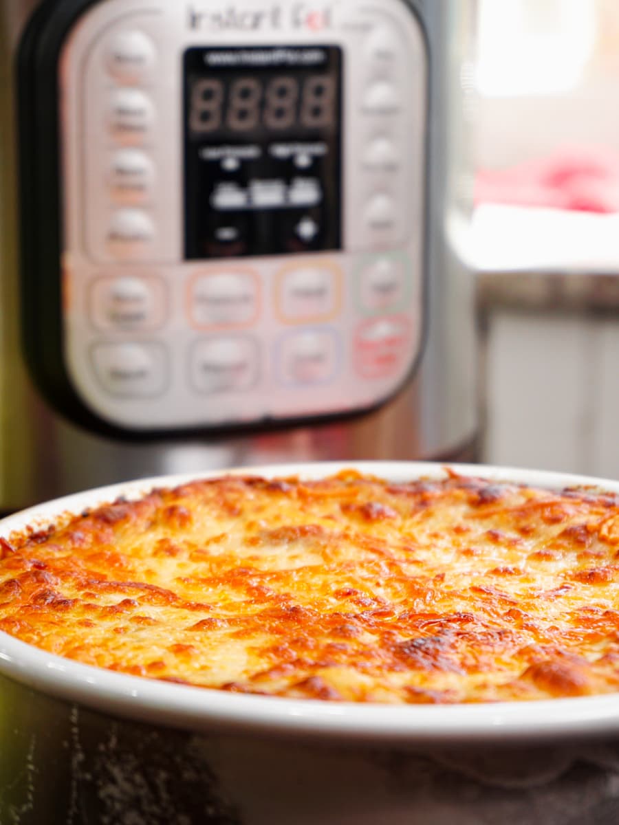 a pan of freshly cooked lasagna sitting in front of an instant pot