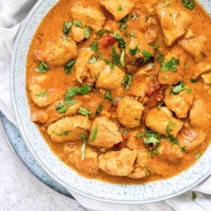 top view of a bowl filled with chicken curry and garnished with cilantro