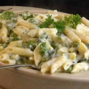 close up of a serving dish filed with creamy garlic veggies pasta