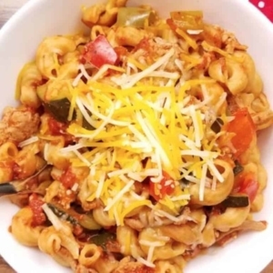 overhead shot a bowl of goulash topped with shredded cheese