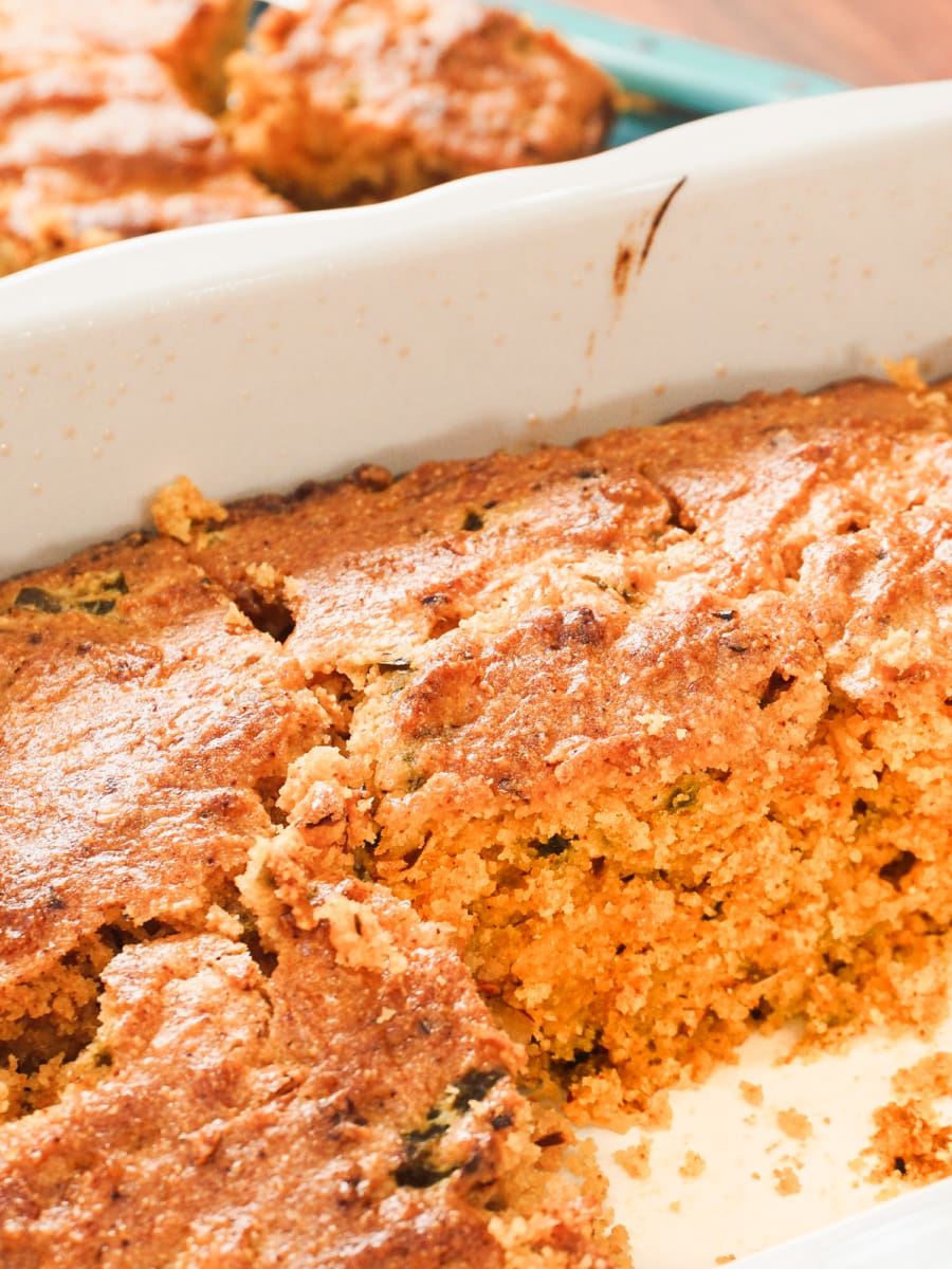 a partially sliced southern cornbread in a baking dish