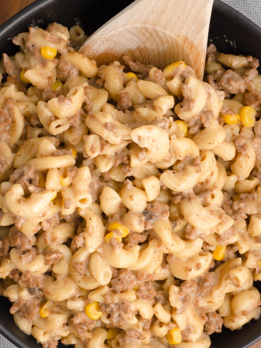 a bowl of macaroni pasta with corn and beef