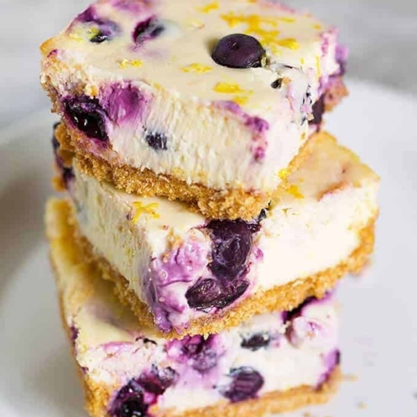 three piece of blueberry lemon cheesecake stacked on top of eachother