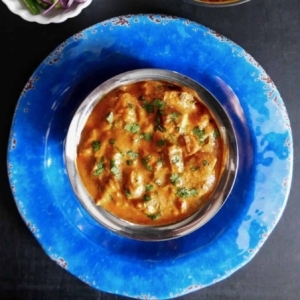 a bowl of tikka masala on top of a plate