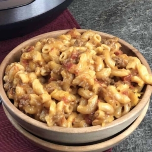 a cheesy ground beef goulash in a large bowl