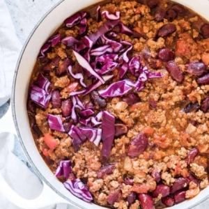 a bowl of chili with pieces of onion