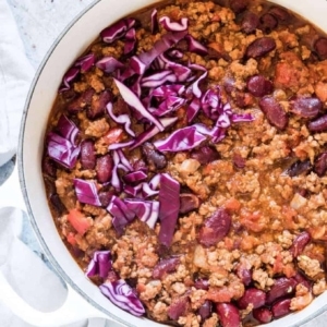 a bowl of chili with pieces of onion