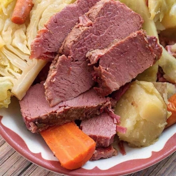 corned beef and cabbage on a plate with pieces of carrots