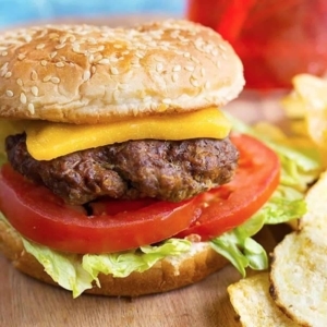 close up of a hamburger with lettuce, tomato, and cheese