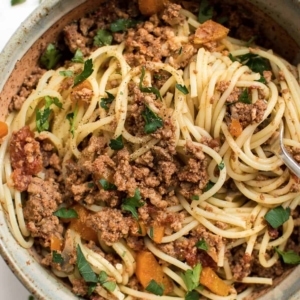 overhead shot of a large bowl with spaghetti and beef garnished with cilantro