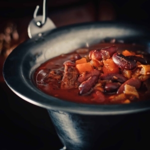 close up of a hungarian bean goulash in a rimmed bowl