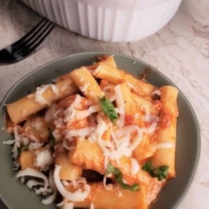 creamy baked ziti on a plate garnished lightly with cilantro