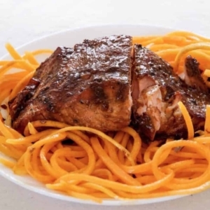 salmon with orange ginger sauce on a plate with fine slices of orange