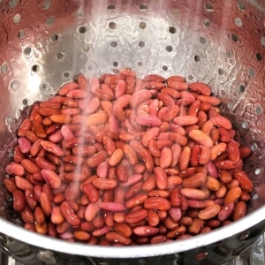 rinsing red kidney beans in a metal strainer