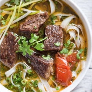 overhead shot of vietnamese beef stew pho noodle soup garnished with cilantro and scallions