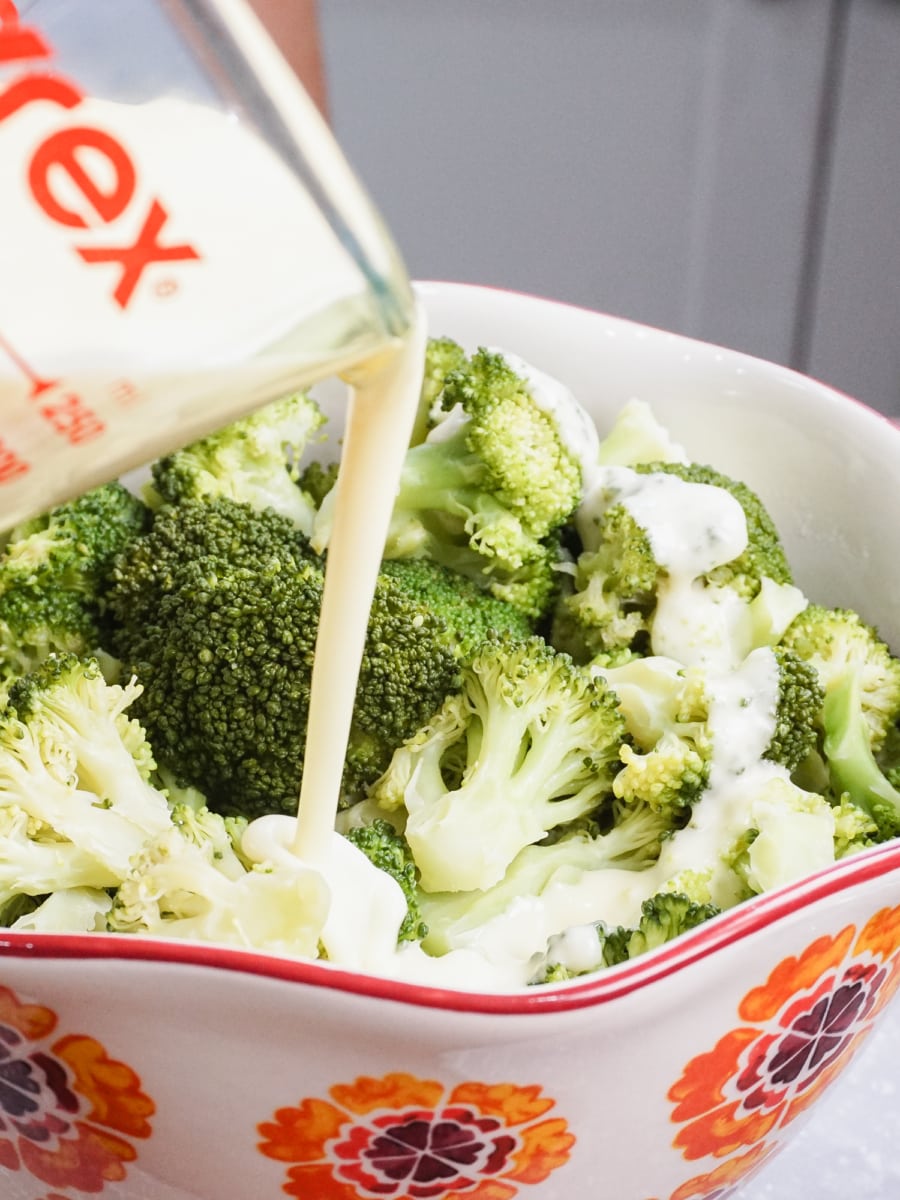 pouring lemon butter sauce on broccoli