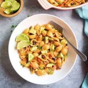 overhead shot of vegetarian fajita pasta garnished with cilantro and two slices of lime