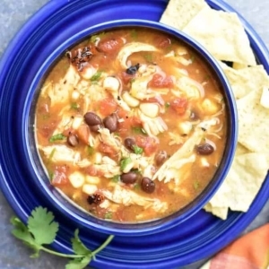 overhead shot of a bowl of chicken tortilla soup centered on a plate