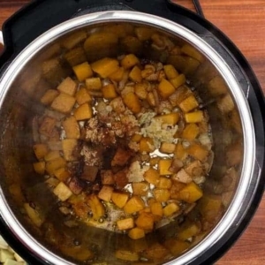 adding spices to butternut squash soup in the instant pot