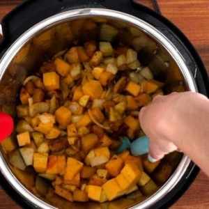 mixing in apples in butternut squash