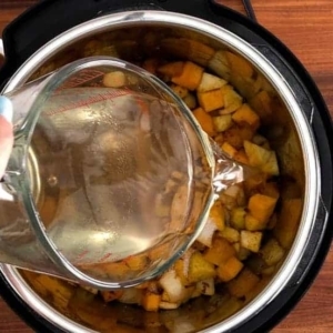 adding coconut water to butternut squash soup in the instant pot