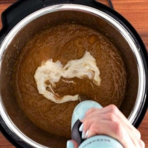 pureeing coconut milk and maple syrup into butternut squash soup