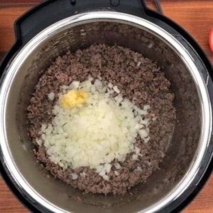 adding onion and garlic to ground beef in the instant pot