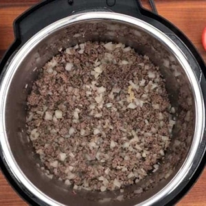 onion and garlic mixed into ground beef and cooked in the instant pot