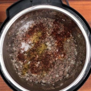 adding spices to the instant pot for making cheeseburger mac