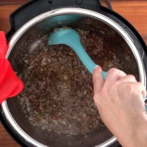 mixing ground beef into beef stock for an instant pot casserole