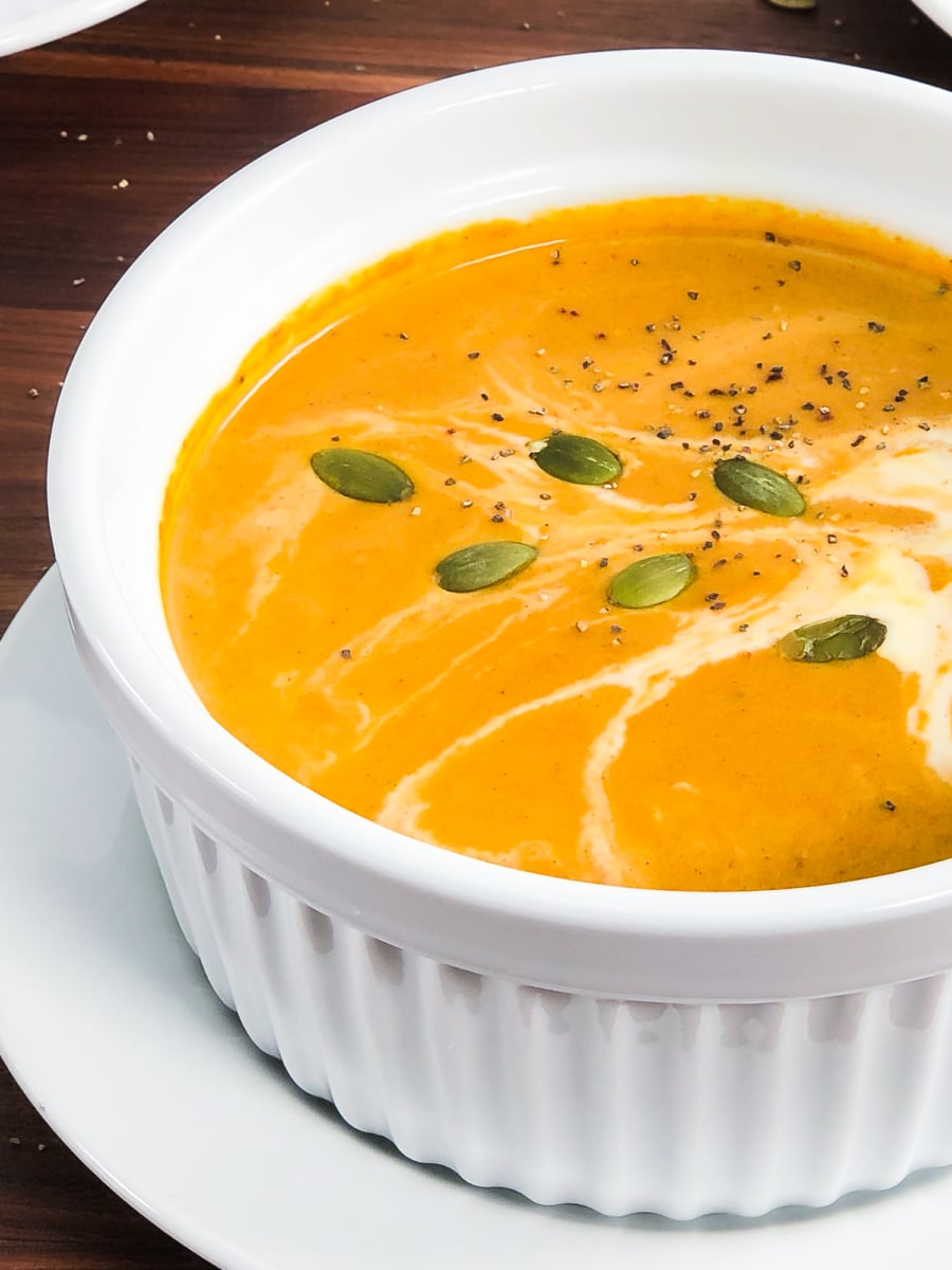 pumpkin soup topped with cream and pumpkin seeds