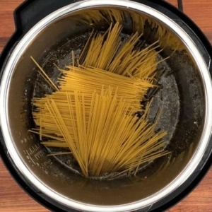 placing spaghetti pasta into the instant pot