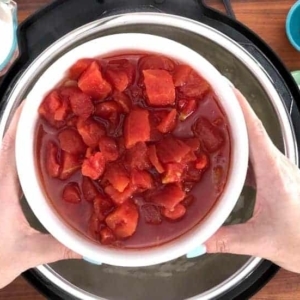 adding tomatoes to tomato soup in the instant pot