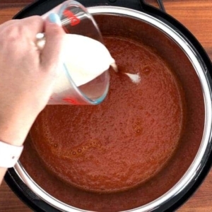 adding cream to tomato soup