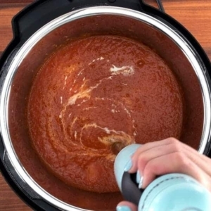 mixing heavy cream into tomato soup