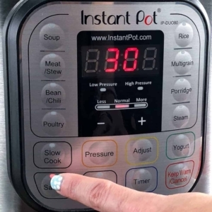 selecting the sauté function on the instant pot to make tomato soup