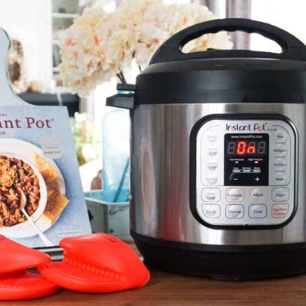 an instant pot book on a recipe holder near an instant pot and instant pot gloves