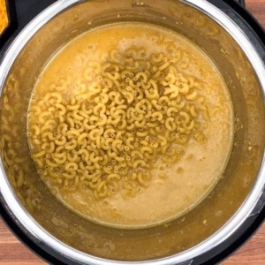 adding elbow pasta to butternut squash in the instant pot