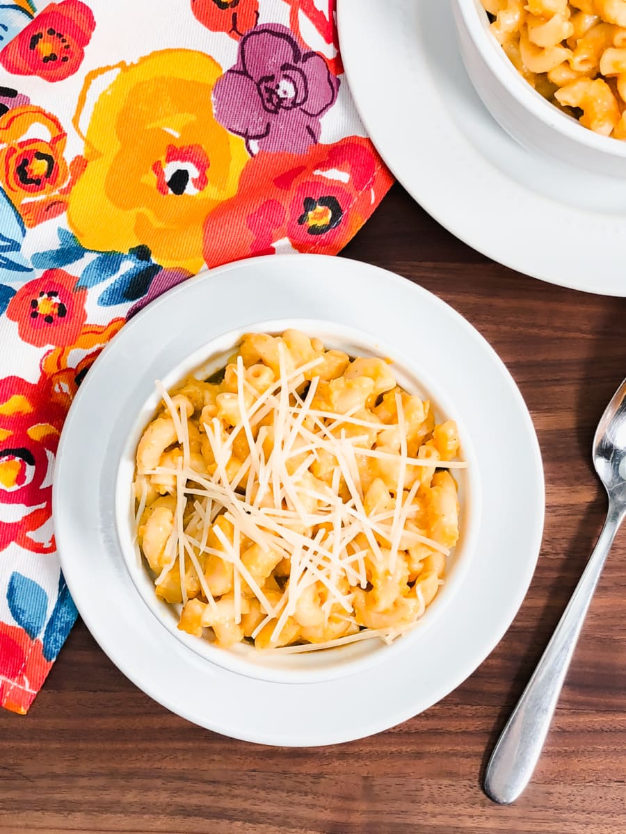 butternut mac and cheese in a bowl on top of a floral towel