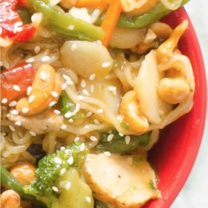 close up of cashew chicken and noodles with sesame seeds