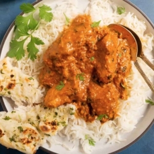 chicken tikka masala on a plate garnished with cilantro