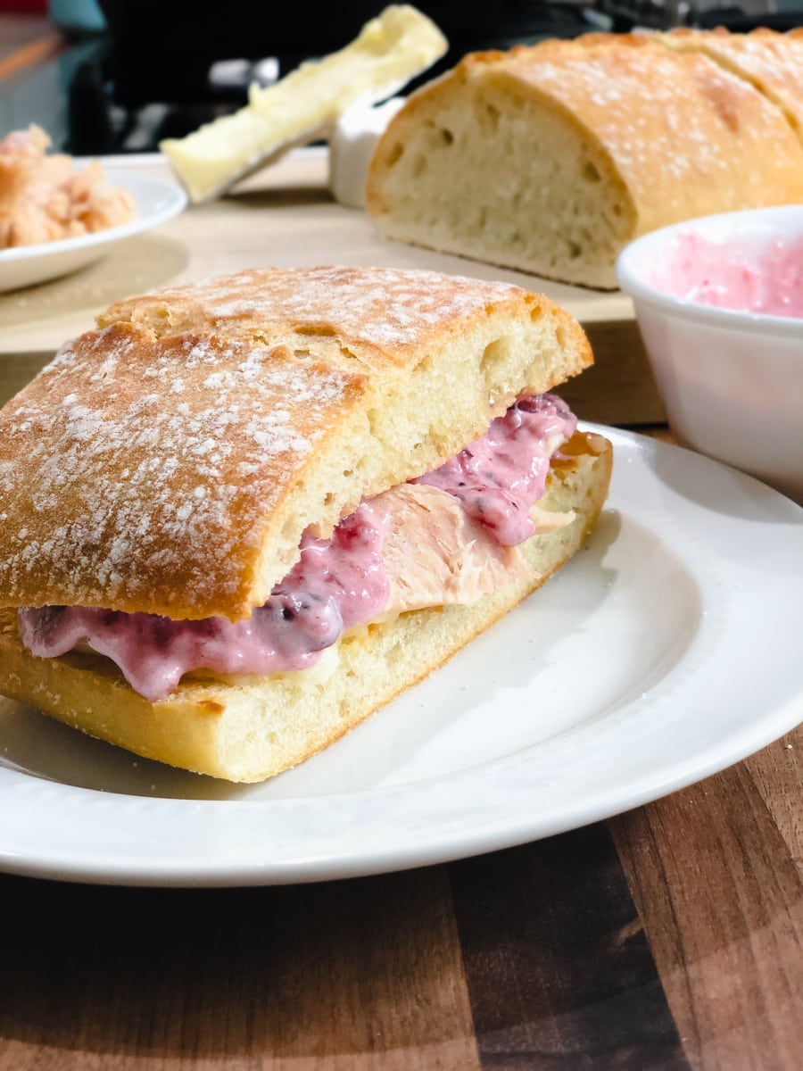 side view of left over turkey sandwich on ciabatta bread with brie and cranberry aioli