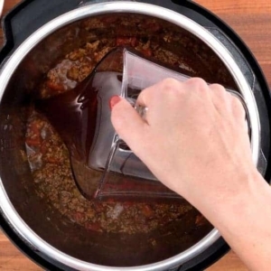 adding unsalted beef broth to the ground beef mixture in the instant pot