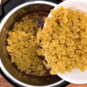 adding bowtie pasta to the instant pot