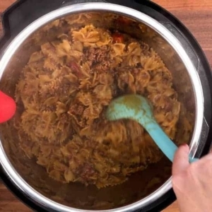 mixing the cooked taco pasta in the instant pot