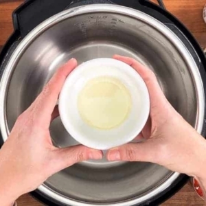 adding avocado oil to the instant pot to saute diced onion