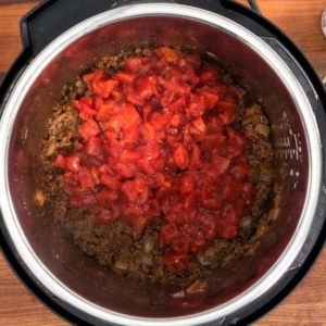 two cans of undrained and diced fire roasted tomatoes are added to the instant pot